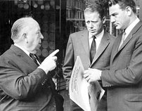 Fig. 2: Hitchcock instruerer Topaz (1969) på hjørnet af Vesterbrogade og Trommesalen i København. Skuespilleren th. læser i et eksemplar af Kristeligt Dagblad.