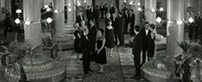 Fig. 3: The woman (Seyrig) moves among a crowd  frozen in space—only the man closest to the camera (whom we have seen earlier)  turns his head as she passes.