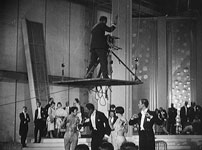Fig. 5. Her virres en kameraplatform hen over et publikum under optagelsen af L’Argent (1928). Billedet er fra Jean Drévilles Autour de l’Argent (1928) – én af filmhistoriens første making-of-film. Ifølge en artikel i The International Photographer havde den legendariske set designer William Cameron Menzies gjort noget lignende ved United Artists i 1930 (”Devises ’Rotary Shot’” 1930, s. 45).