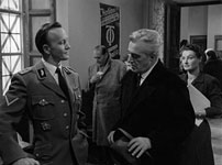 Fig. 9. Filmens centrale tema – forholdet mellem iscenesætteren og den iscenesatte – ekspliciteres med Rossellinis cameo i tyskernes hovedkvarter. Det er Rossellini, der diskret påkalder sig opmærksomhed bag fiktionens instruktør og skuespiller (oberst Müller og Bardone).