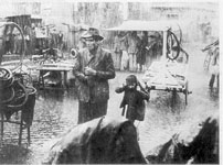 Fig. 10: Far og søn bliver overrasket af regnen og må vente på, den holder op. De Sica ventede dog ikke på, at det skulle give sig til at regne. Han fik brandvæsenet til at give en hånd.