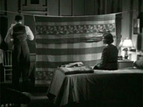 Fig. 18: Clark Gable og Claudette Colbert i “It Happened One Night”. Parret må dele hotelværelse og hænger et tæppe op mellem de to senge. Adskillelsen kaldes i filmen ”The Walls of Jericho”, og i slutscenen låner Peter Warne (Clark Gable) en trompet og blæser muren ned, så de to kan forenes.