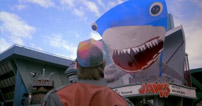 Fig. 6. Franchises på franchises. I en lille in-joke i anden del af Back to the Future-trilogien (1989) tror Marty (Michael J. Fox), at han bliver spist af en haj. Hajen viser sig, i denne 80’er-agtige fremtidsverden, at være et kikset hologram, brugt som et led i promoveringen af Jaws 19 – en fiktiv, ironisk hilsen til et af tidens andre franchises (ganske som Back to the Future-filmene, produceret af Steven Spielberg).