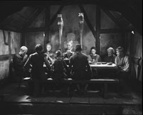 Under bespisningen. Morderne er isoleret i billedet udenfor det ovenfra  strømmende lys, her anvendt af Bergman som et kristent nådessymbol.