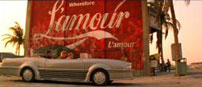 Fig. 11: Den store ”Wherefor L’amour” reklame kommenterer både på Romeos skødesløse hang til kærlighed i filmens start og på konsekvenserne heraf, da Romeo mod filmens slutning jagter Tybalt efter kampen på stranden.