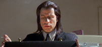 Fig. 4: Travolta i Pulp Fiction (1994). I det øjeblik kufferten åbnes, er der en svag, susende lydeffekt, der nærmere virker underbevidst end opmærksomhedskrævende. En næsten ikke-eksisterende lydeffekt.